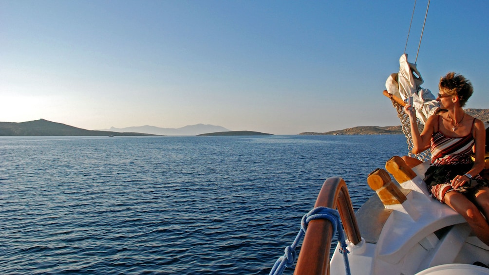 Woman sitting on a sailboat at dusk in Mykonos