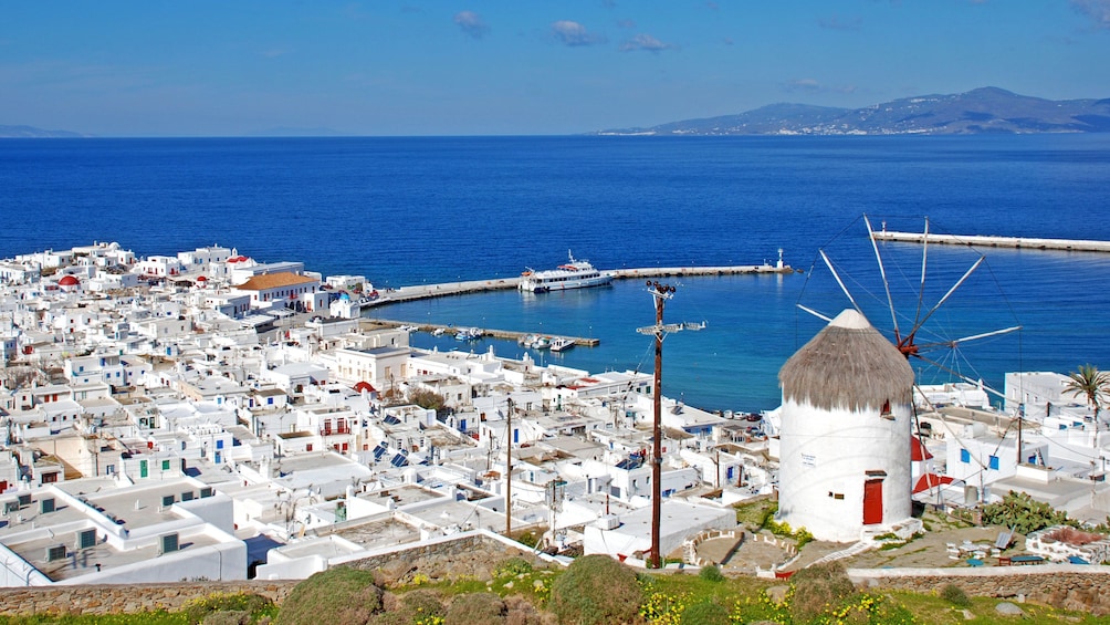 Windmill on a hill with the city below in Mykonos