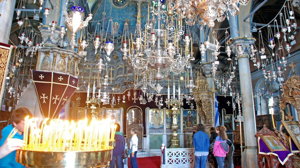 Chandeliers and incense burners hang from the ceiling at a church in Tinos