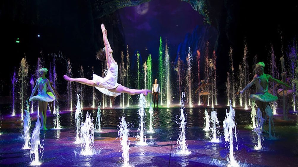 Tampilkan item 4 dari 5. women dancing and leaping amidst many water fountains.