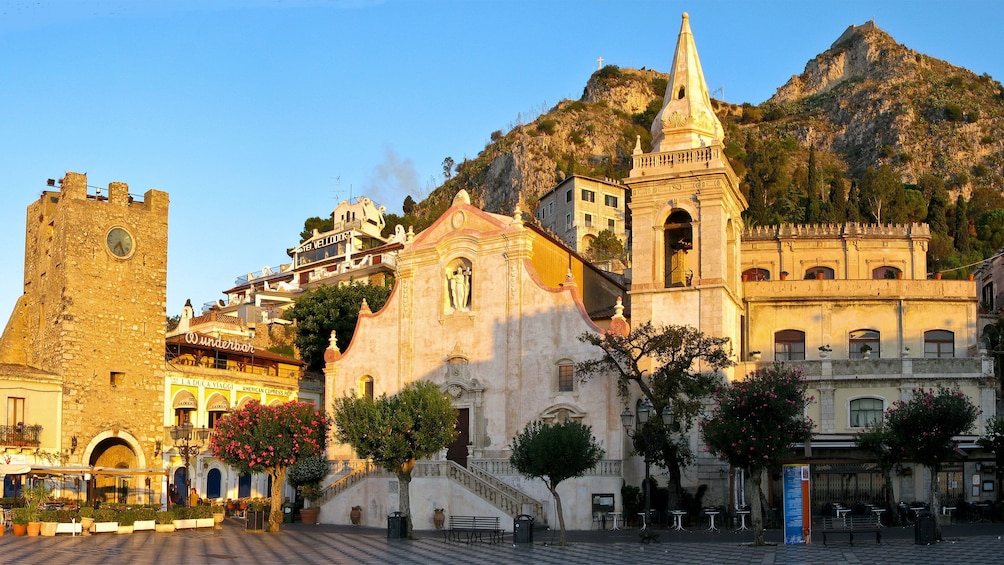 Historical buildings in the city center with mountains in the background in Taormina