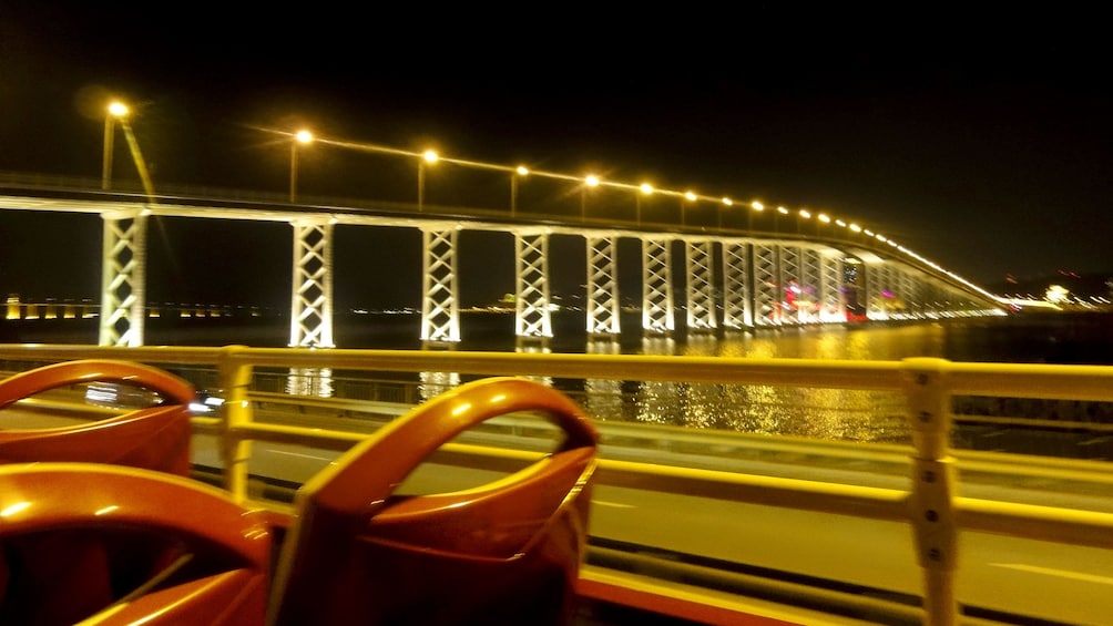 Show item 5 of 5. Driving past a Macau bridge at night.
