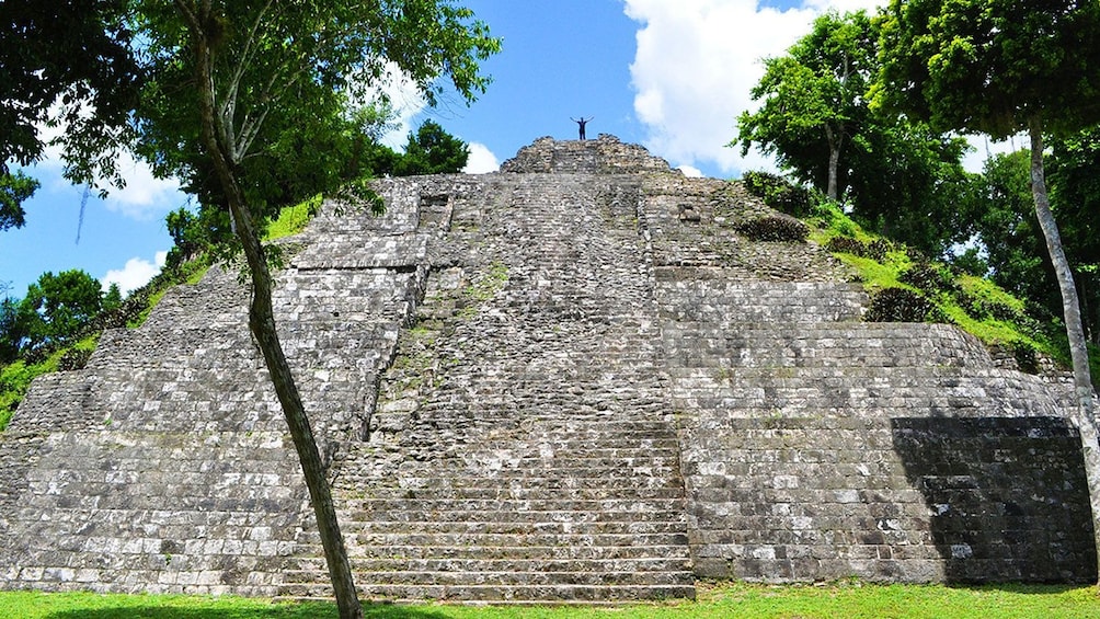 Person on top of temple in ancient Mayan settlement of Tikal