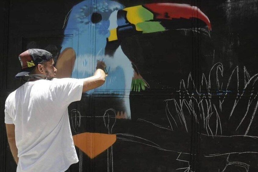 Graffiti artist completing his art on the Olympic Boulevard.