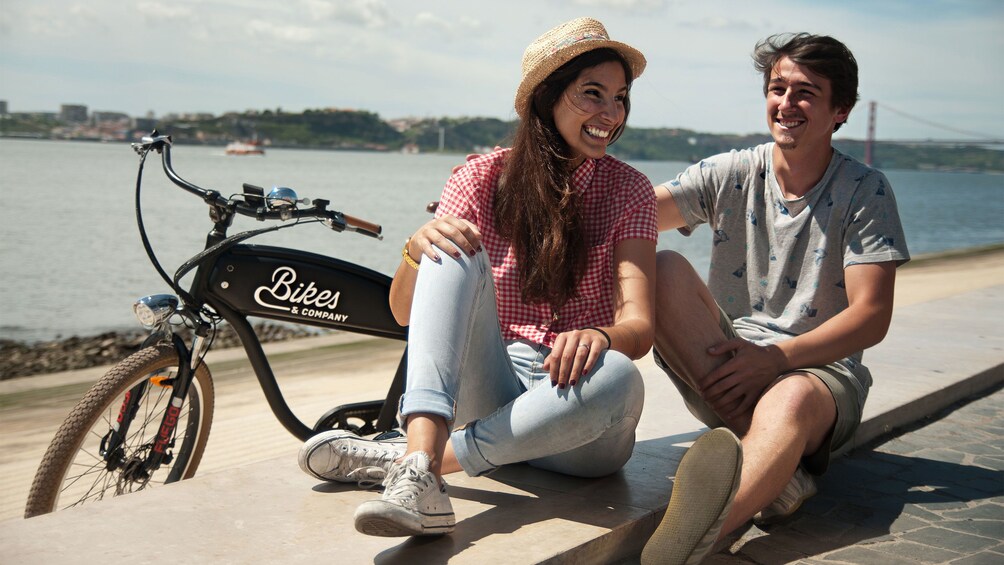 Bicycling couple taking a rest near the coast in Lisbon