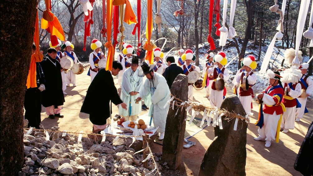 People in traditional clothes performing a traditional shamanistic rite at a Korean Folk Village