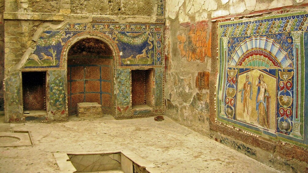 Interior of ancient building with artwork on the walls in Pompeii