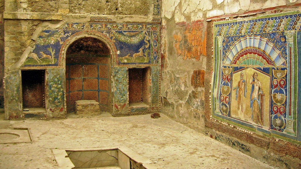 Interior of ancient building with artwork on the walls in Pompeii