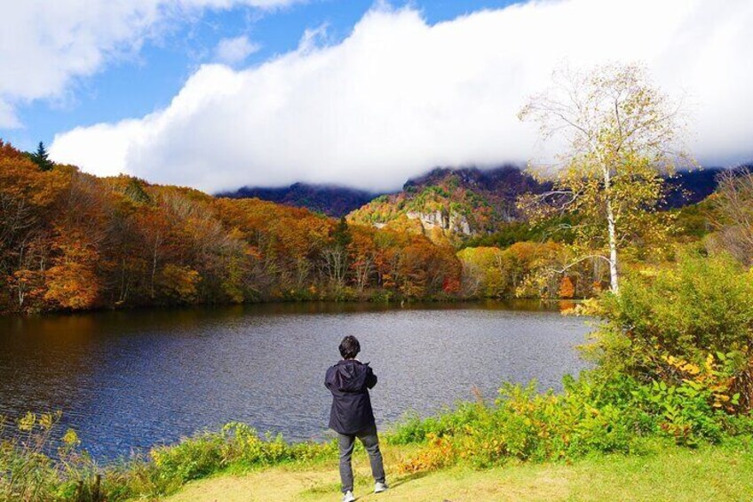Taking in the serene view of Kagami-ike Pond in autumn.