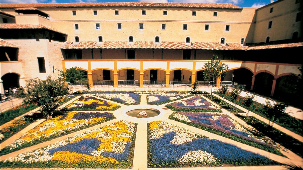 Charger l’élément 1 sur 5. colorful flowers around a fountain inside a plaza in Avignon