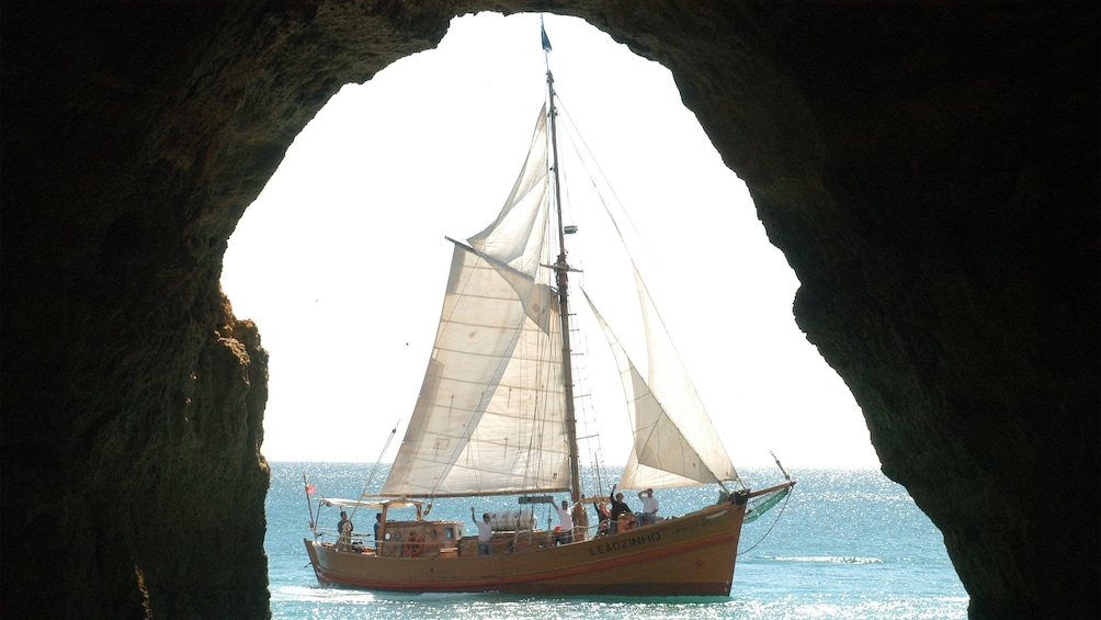 View of a sailboat from inside a sea cave along the coast of Algarve