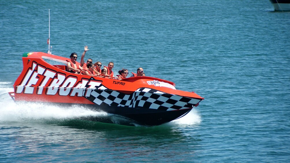 Jetboat with passengers speeding through the water off the coast of Algarve