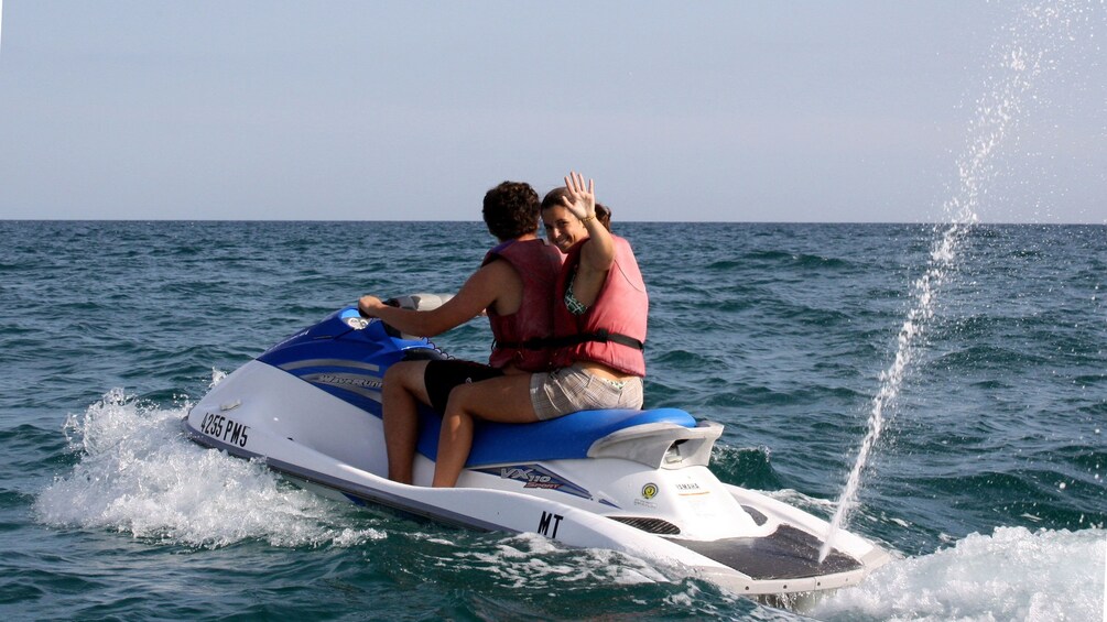 Jet skiing couple in the water off the coast of Algarve