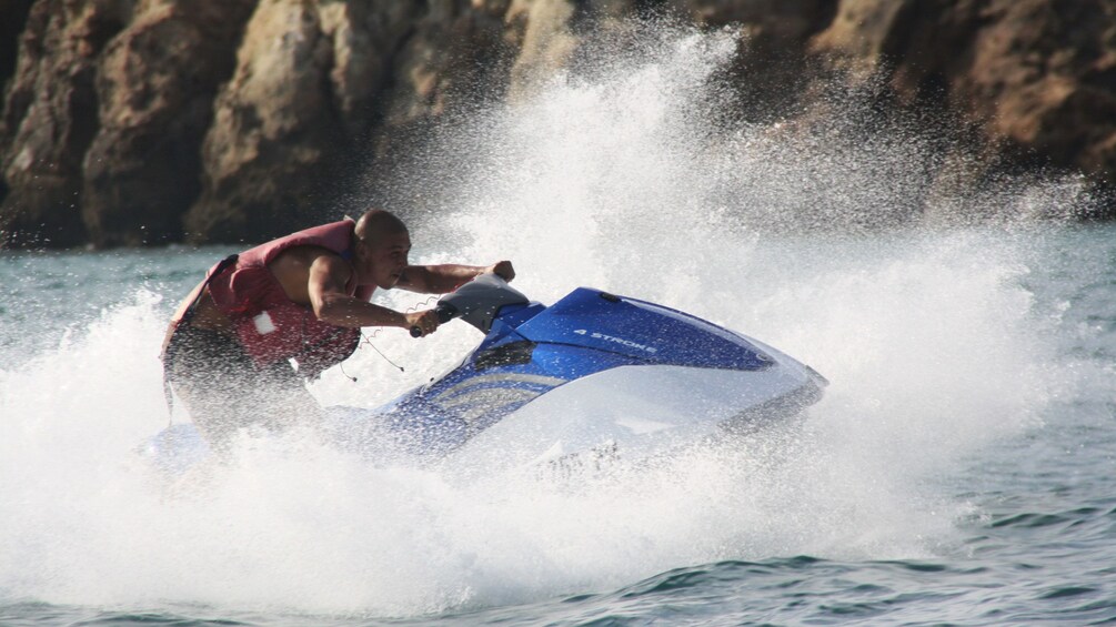 Jet skiing man splashing through the waves in Algarve