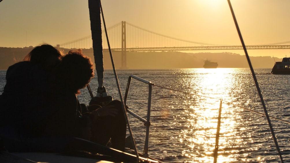 Couple looking at the sunset from a sailboat in Lisbon