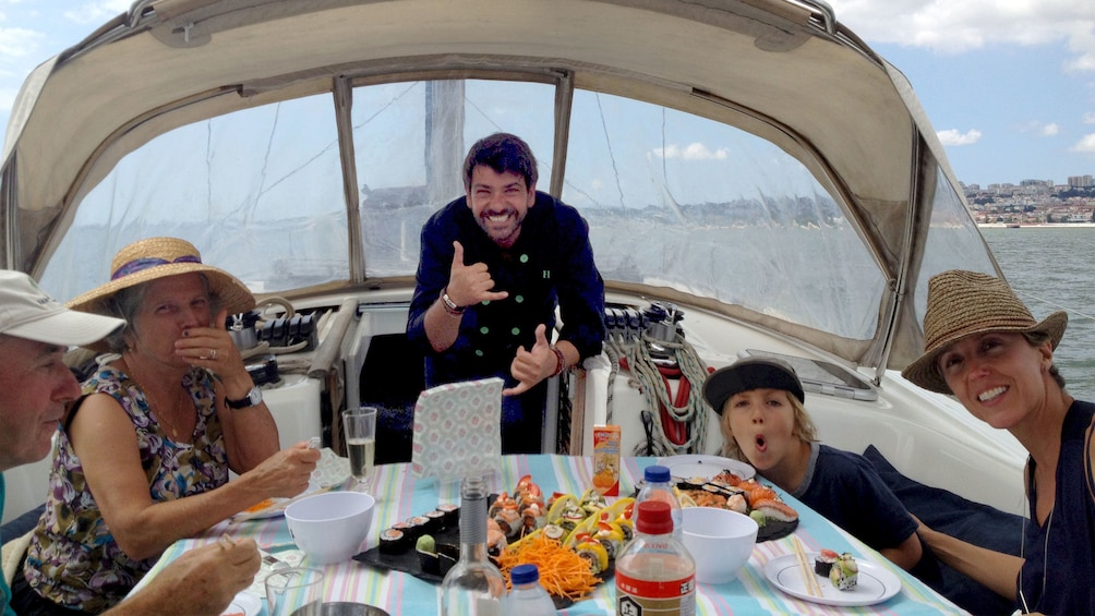 Group with captain dining on sushi on a sailboat in Lisbon