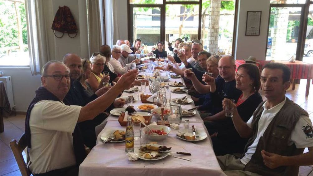 Group having lunch with wine in Greece