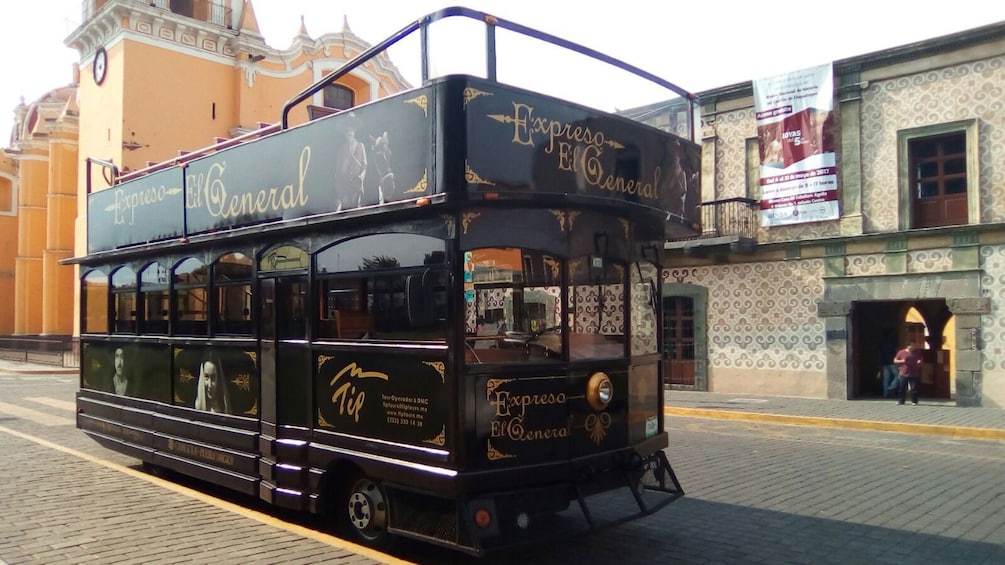 Empty double decker tour bus parked on street in Puebla