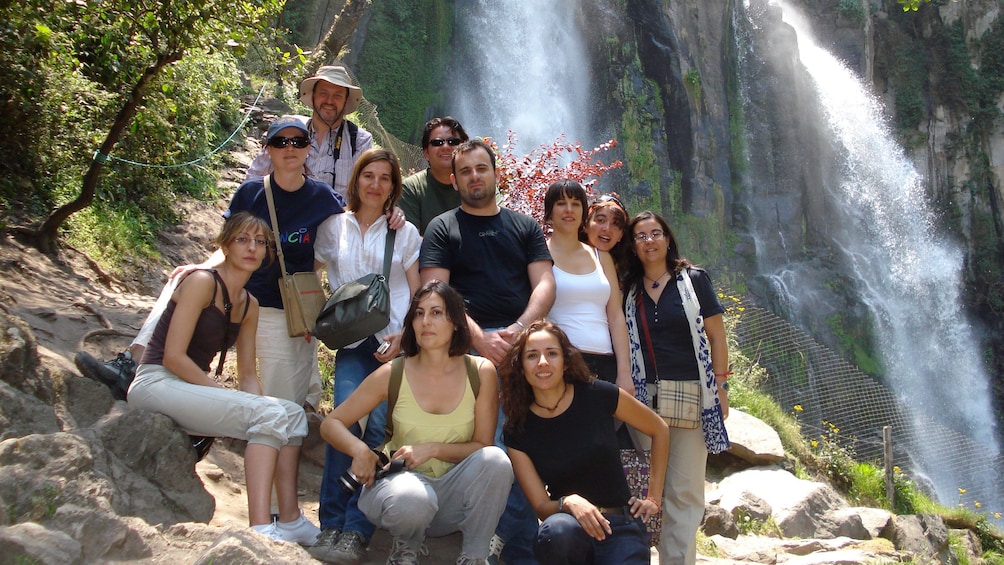 Tour group takes a picture in front of the waterfalls in Puebla 