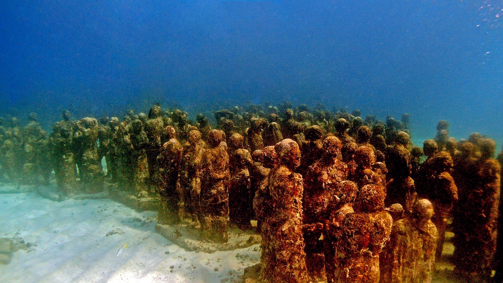 Swimming along underwater statues in Mexico
