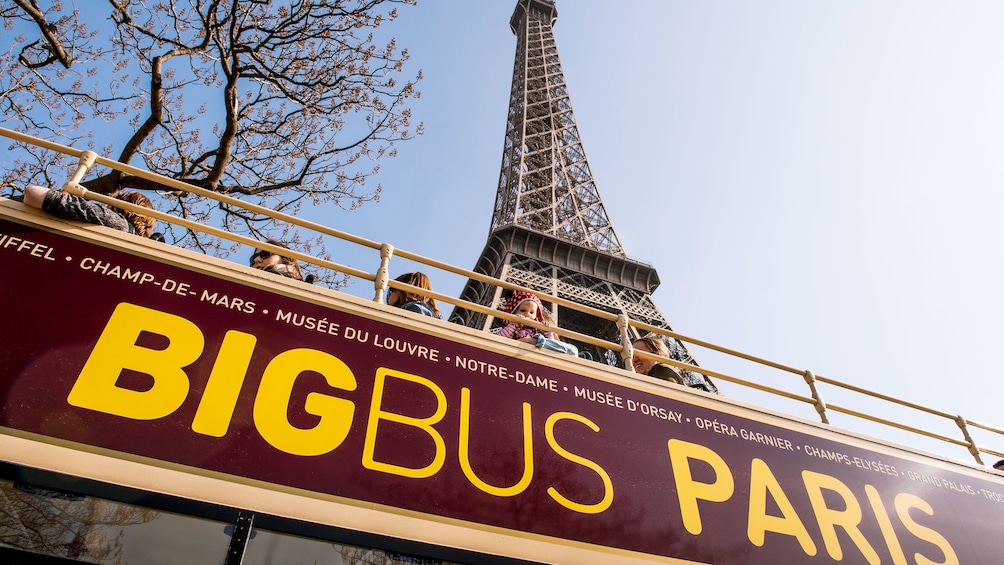 Hop on Hop off bus driving past the Eiffel tower in paris