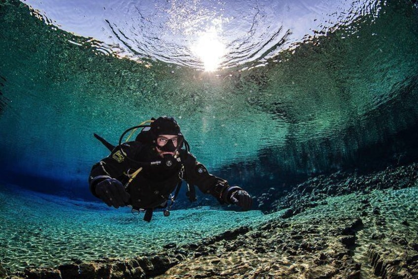 Diver enjoying the colorful clear water in the Silfra lagoon