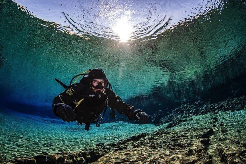 Diver enjoying the colorful clear water in the Silfra lagoon