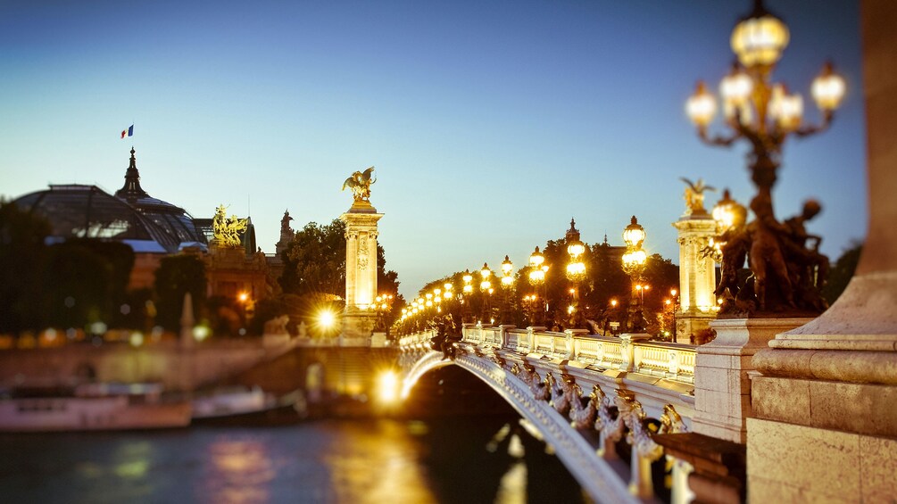 Illuminated bridge across the Seine river in Paris at night