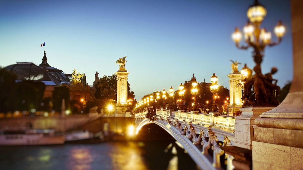 Illuminated bridge across the Seine river in Paris at night