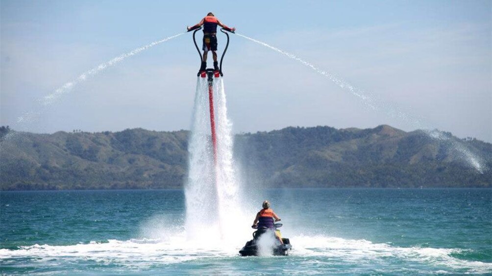 Flyboarder in the air over a jetskieri in Tenerife