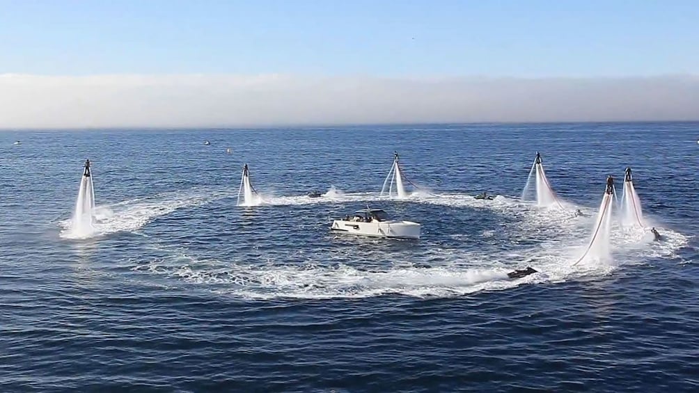 Flyboarding group form a circle in the air around a boat in Tenerife