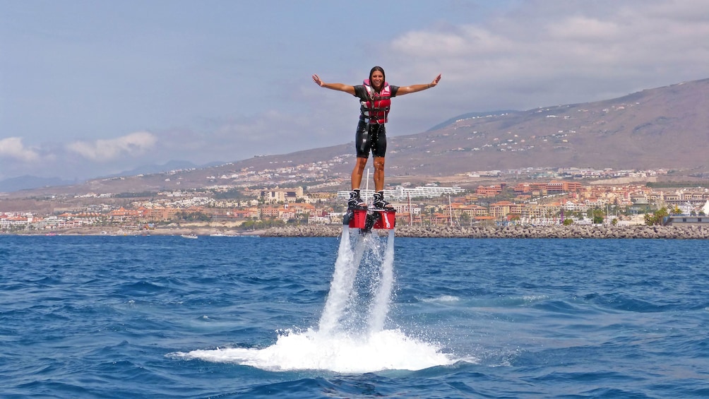 Smiling woman on flyboard over the water in Tenerife