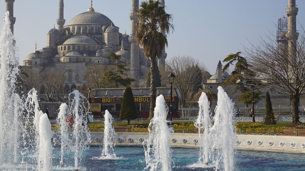 Show item 5 of 10. Hop-On Hop-Off bus passes by fountains outside of the Hagia Sophia Museum
