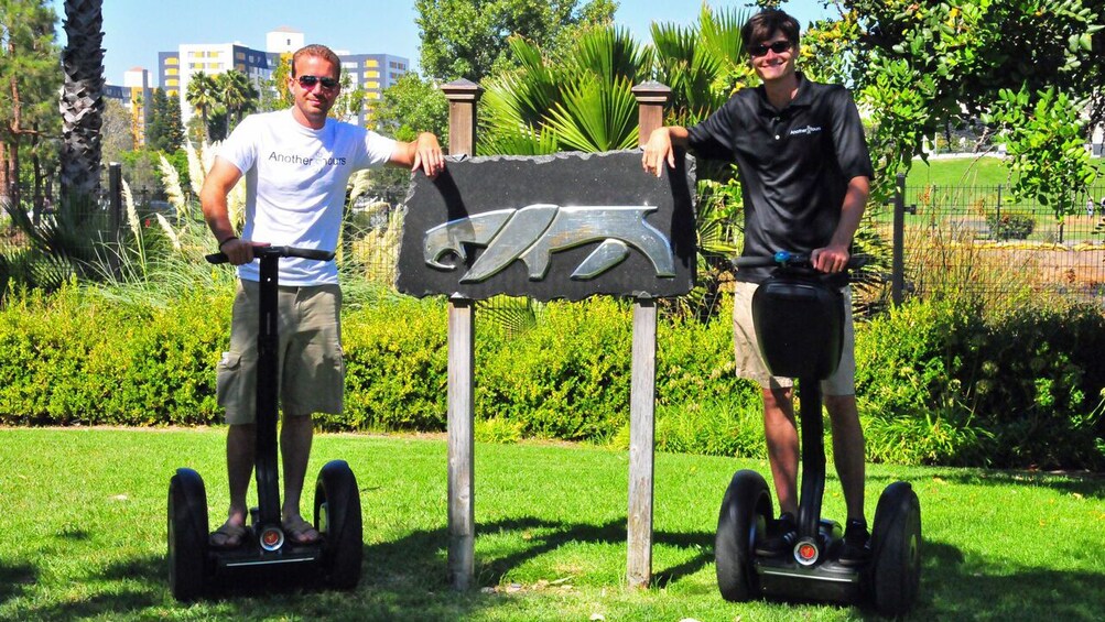 Segway riders posing near saber tooth sign in Los Angeles