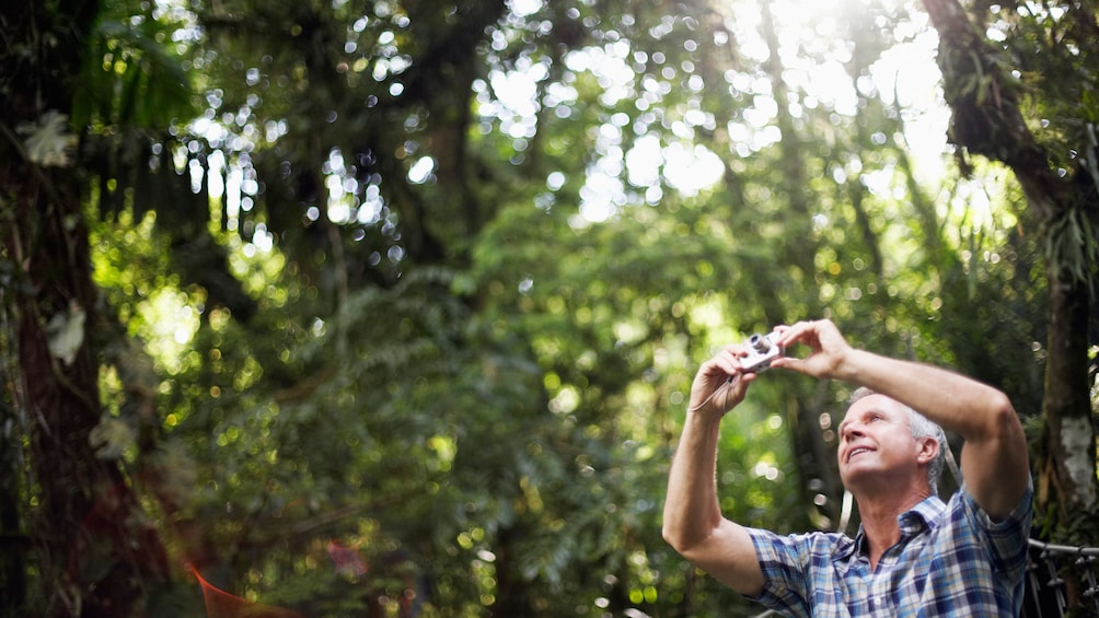 man taking pictures of his hike in the forest in Grenada