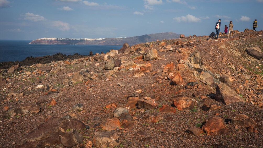 hiking up the rocky coastline in Santorini