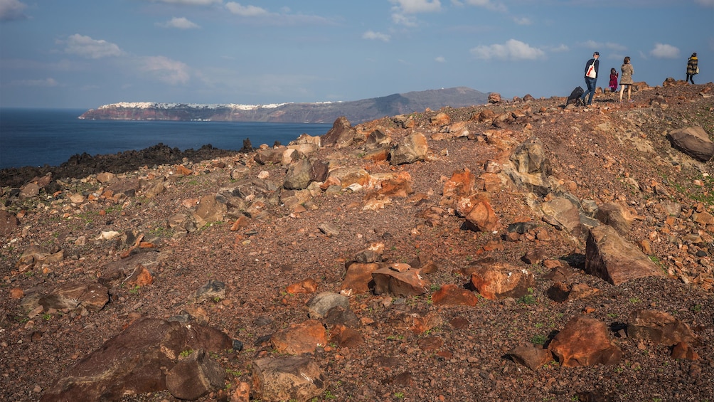 hiking up the rocky coastline in Santorini
