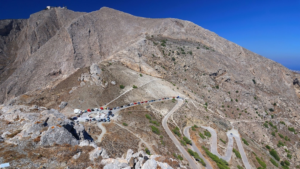 cars parked on a steep side of a mountain in Santorini