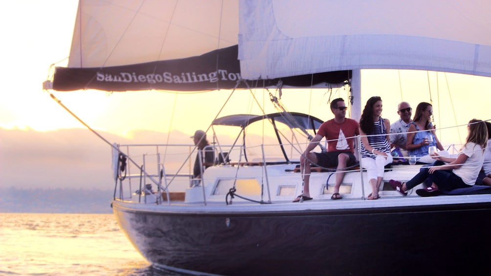 People enjoying time on deck of sailboat at sunset in San Diego