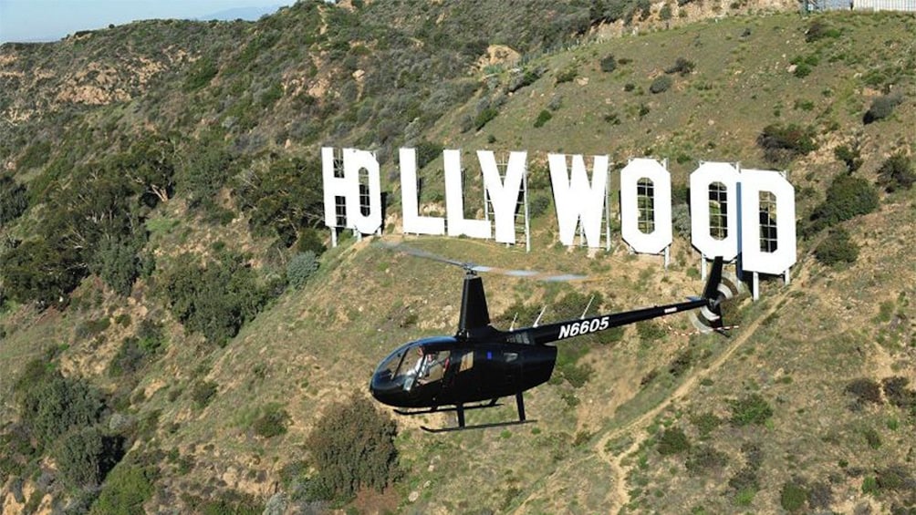 helicopter circling around the Hollywood sign on the hills in Los Angeles