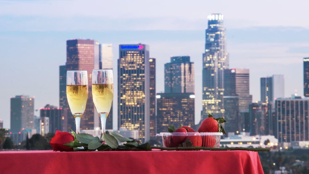 Two glasses of champagne and strawberries on a table overlooking the city in Los Angeles 