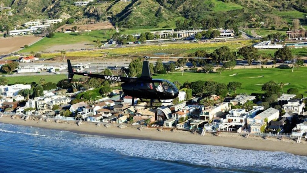 helicopter soaring along the beach in Los Angeles