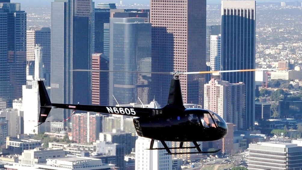 Black helicopter flying above Los Angeles city during the day 