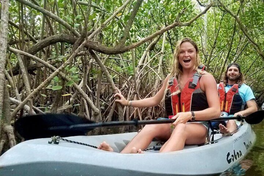 A couple smile as they kayak through the mangrove tunnels in the Thousand Islands Conservation Area. Fin Expeditions Kayak Tours is rated one of the top things to do in Cocoa Beach, Florida! 