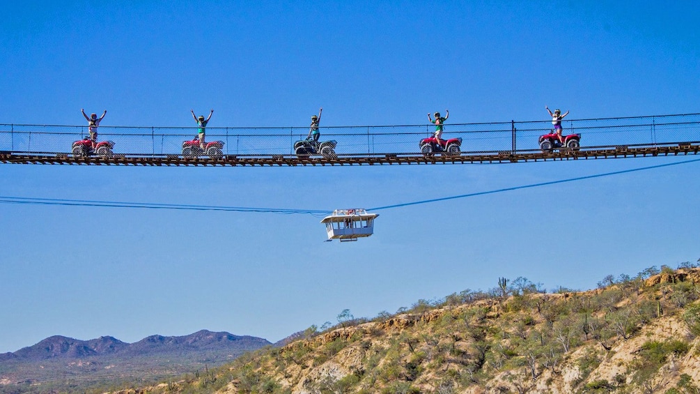 Riding ATVs across a narrow suspended bridge