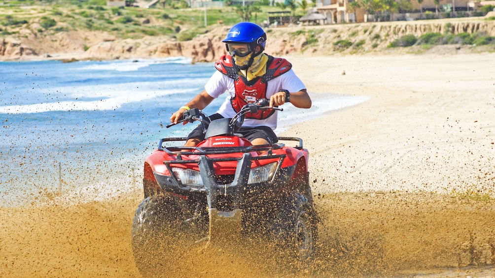 ATV splashing wet sand at the beach in Los Cabos