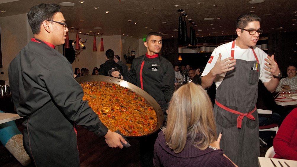 chef explaining giant pan of Paella