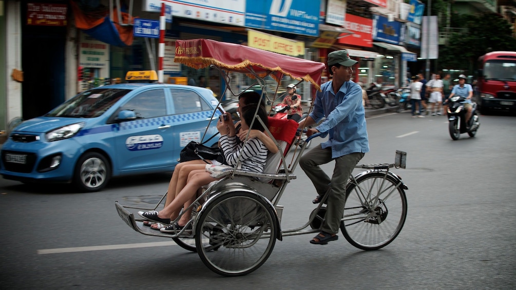 Mother and daughter in a rickshaw in the city in Hanoi