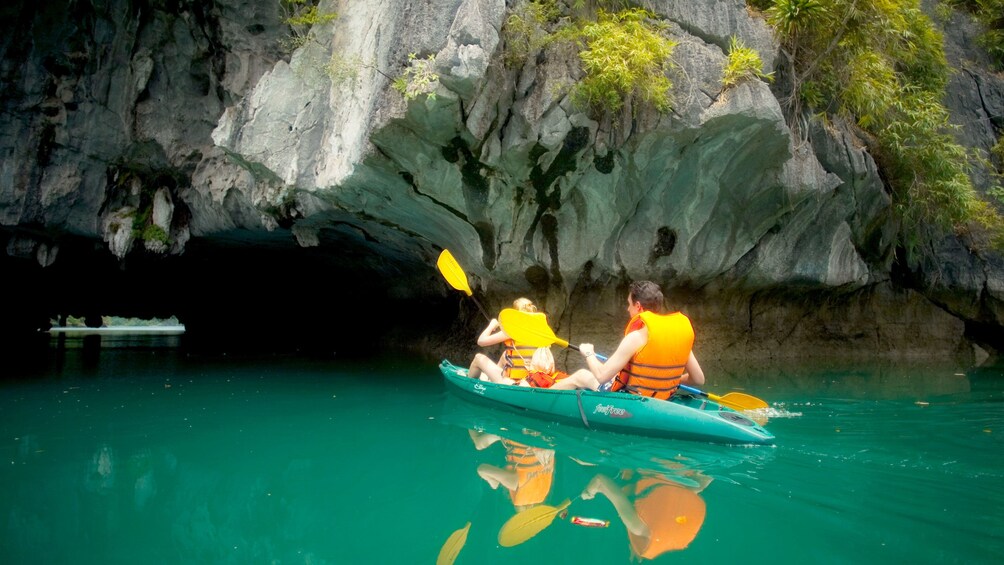 Kayaking group entering a cave in Halong Bay