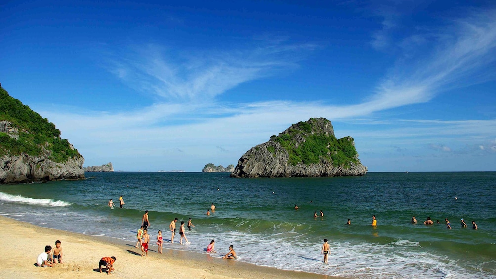 Beachgoers playing in the water in Halong Bay
